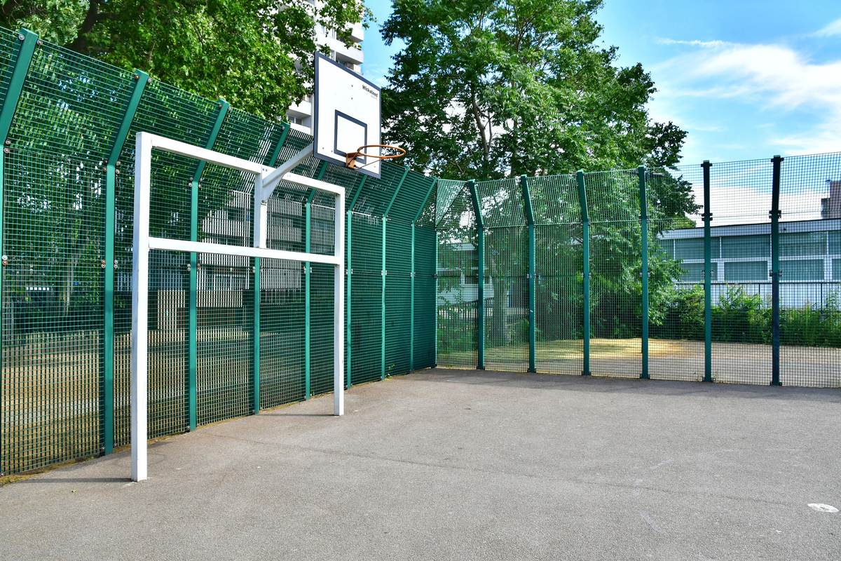 Multi-use games area with basketball hoop and rebound fencing